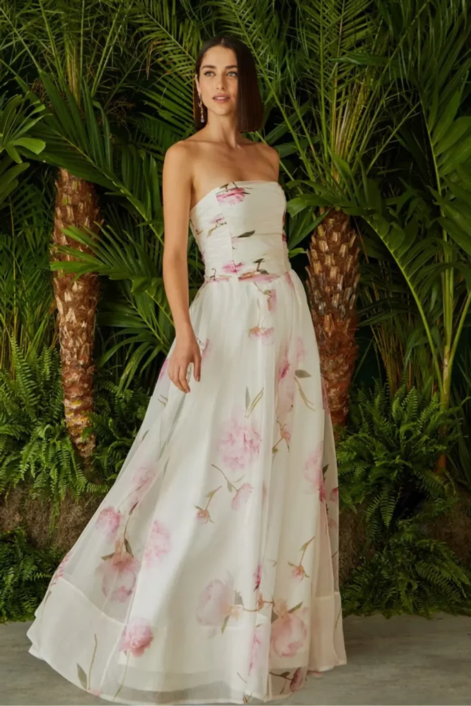 modelo utilizando vestido longo floral em frente a um jardim